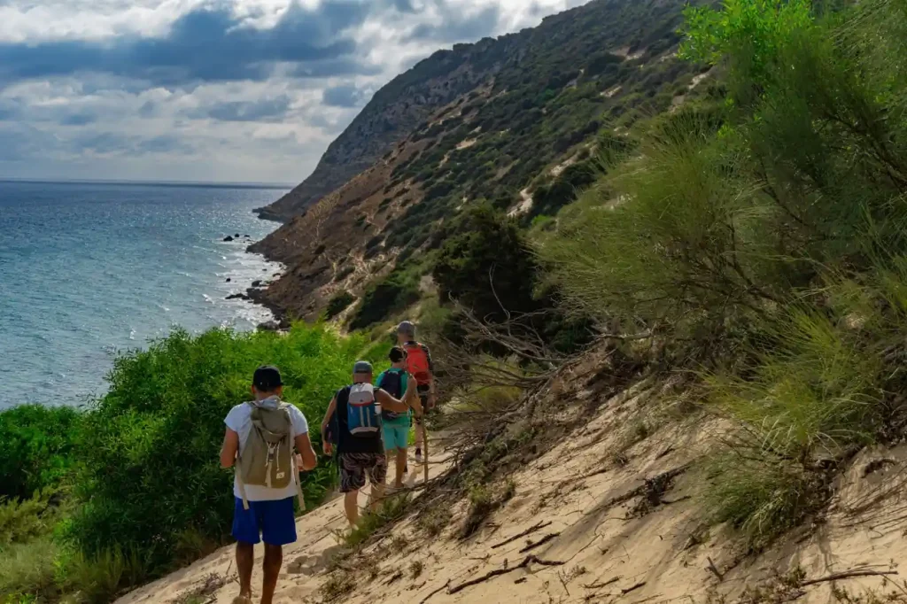 Travelers walking a rugged coastal path, similar to scenic hiking in the BVI.