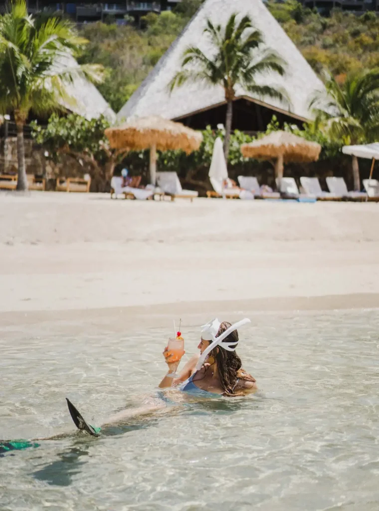 Guest snorkeling in the clear waters at Rosewood Little Dix Bay beach.