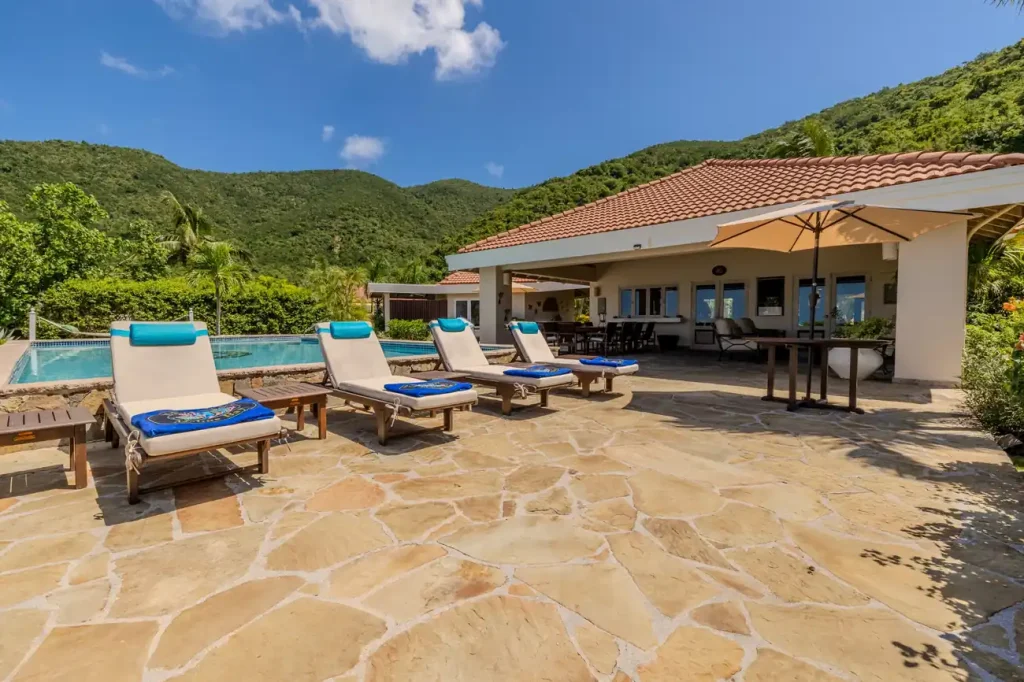 Pool terrace and loungers at Sea Fans villa in Mahoe Bay