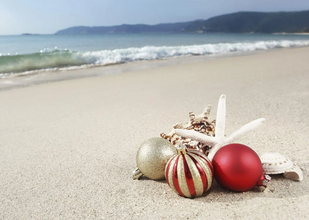 Christmas ornaments on a sandy beach inspired by Christmas in July BVI